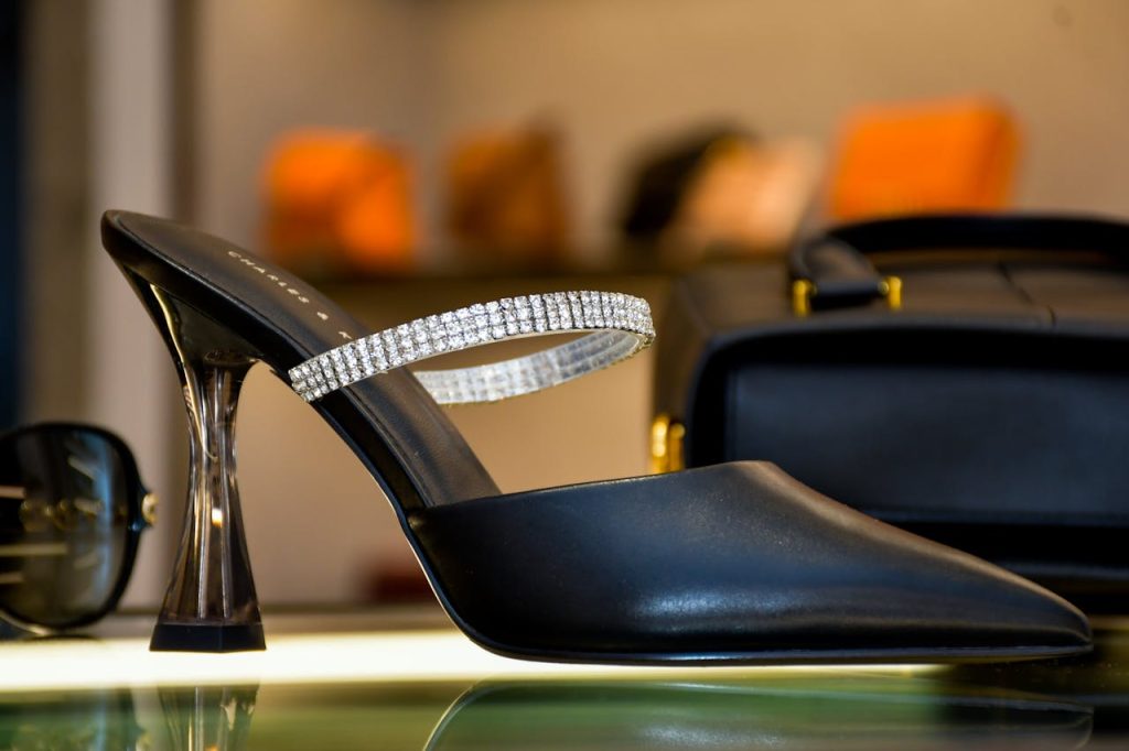 Elegant black high heel with crystal embellishments on display in a luxury store.