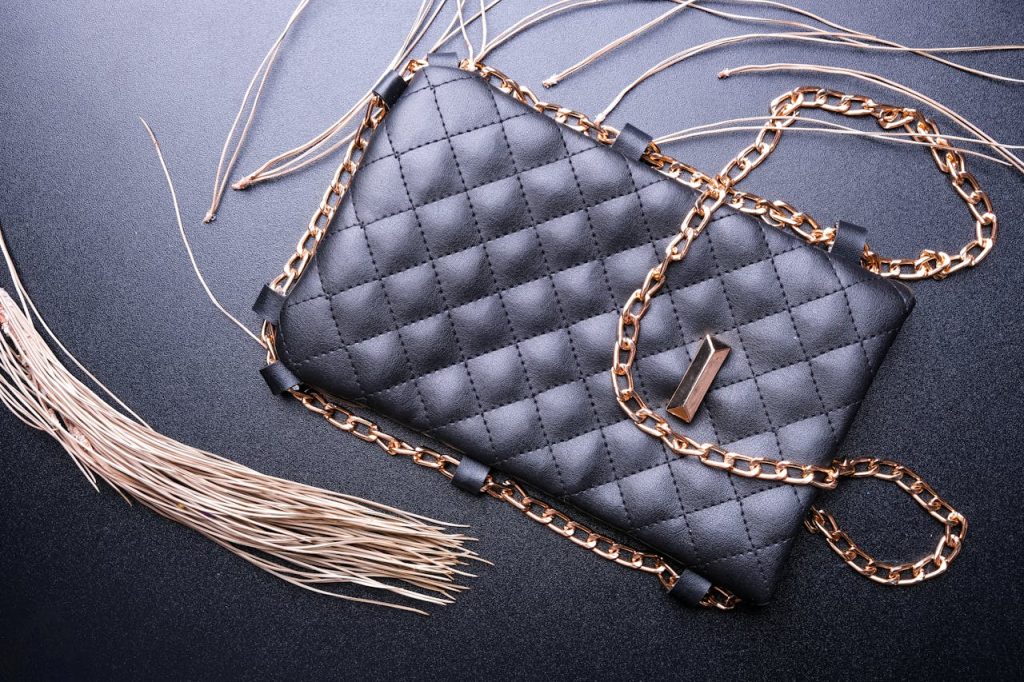 Stylish black purse with a quilted pattern and golden chain strap, showcasing elegance.