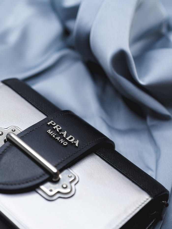 Elegant Prada handbag on soft silk fabric, showcasing luxury fashion style.