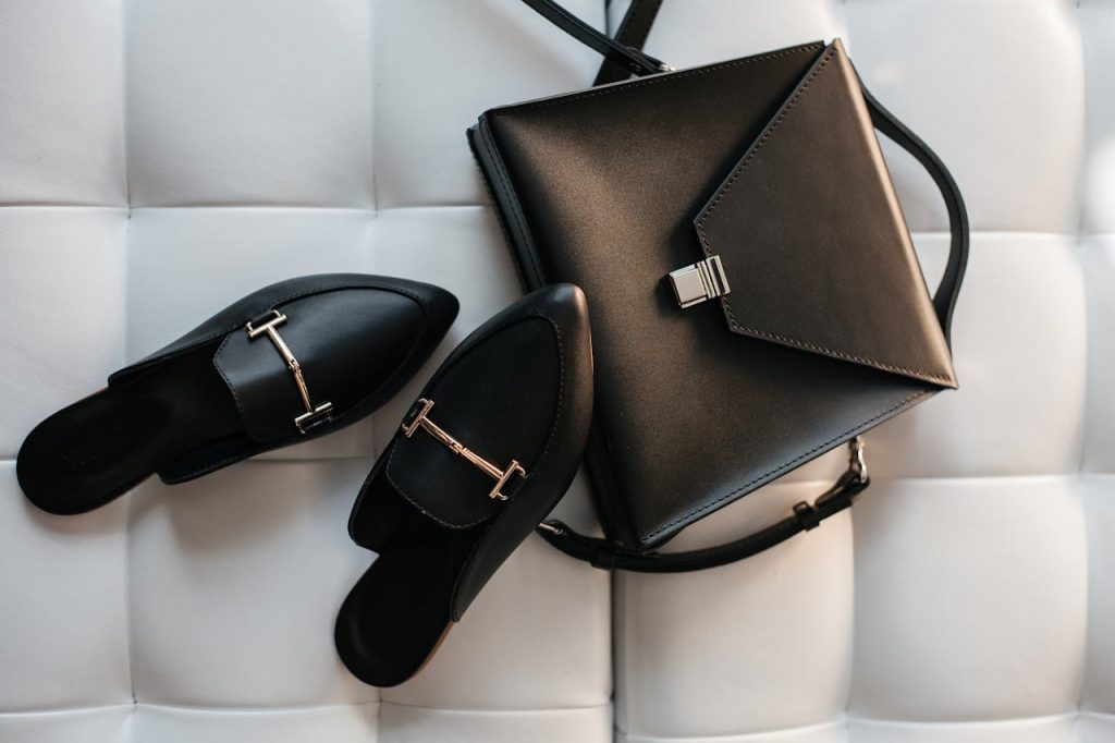 Elegant black leather handbag and shoes displayed on a stylish white background.